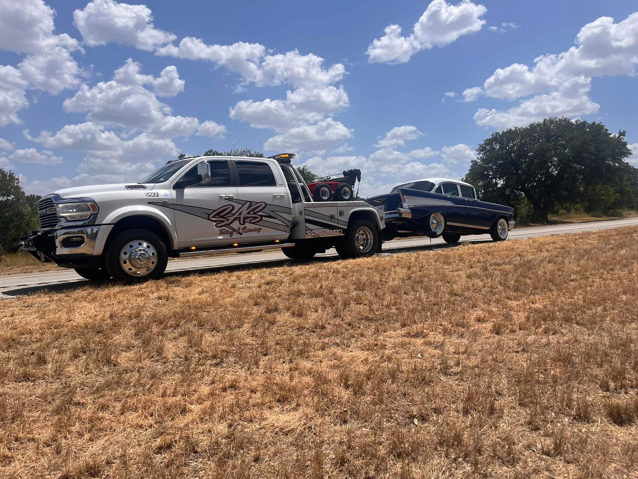 Light duty towing lometa TX wrecker towing a vintage Chevrolet Bel Air on rural roadside